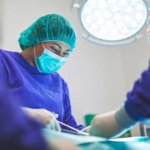 Surgeons in protective gear performing an operation in a sterile environment.