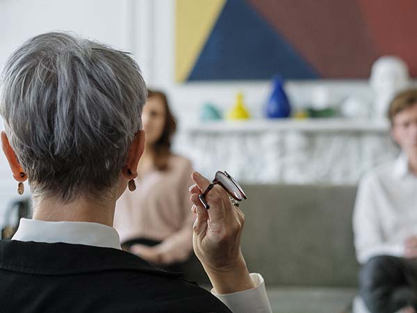 A therapist listens attentively to a patient during a session.
