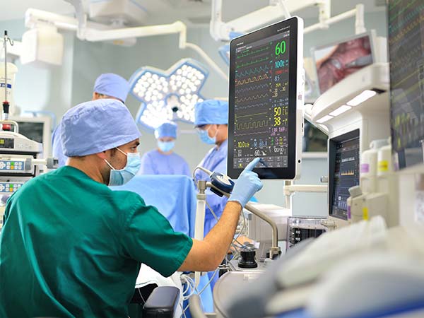Medical professionals monitor vital signs in an operating room.