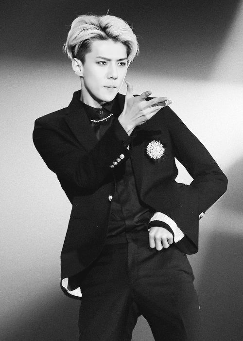 Performer in black suit striking a pose.