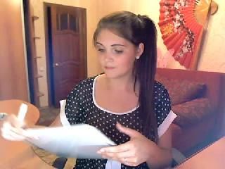 Woman holding paper, sitting in a room.