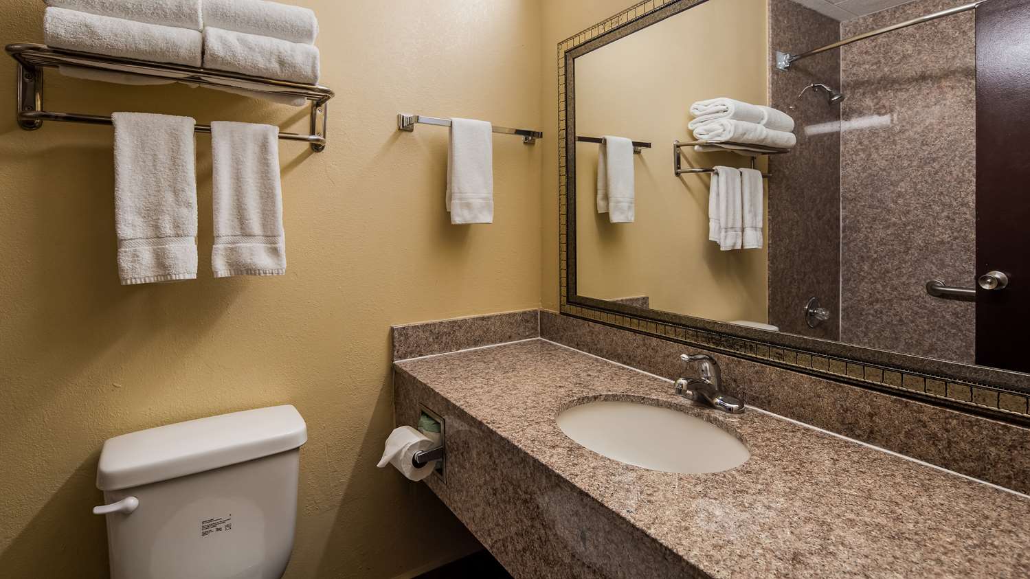 Hotel bathroom with towels and large mirror.