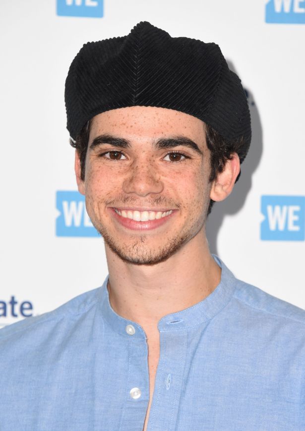 Smiling person wearing a black hat, indoors.