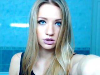 Person taking a selfie in blue room.