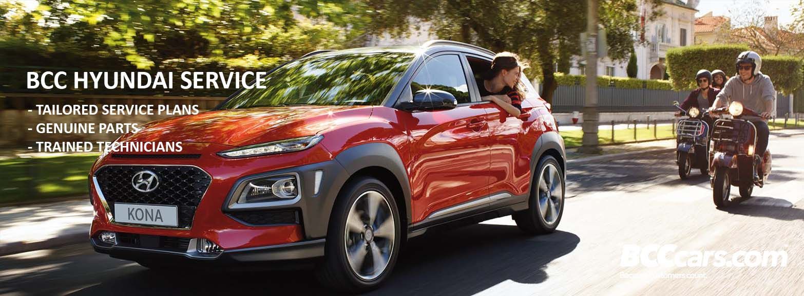 Red Hyundai Kona driving alongside motorcyclists.