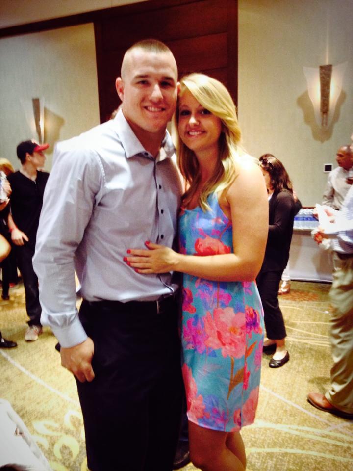 Couple smiling at indoor event gathering.