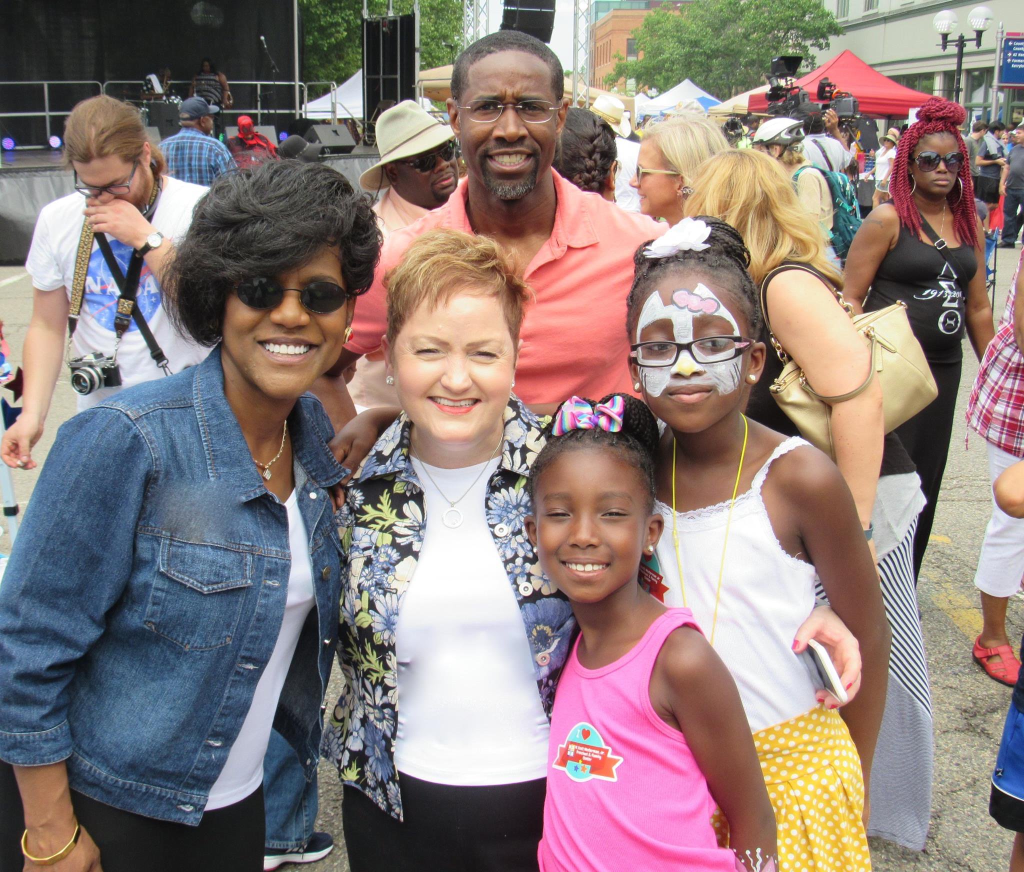 Group of people smiling at outdoor event.
