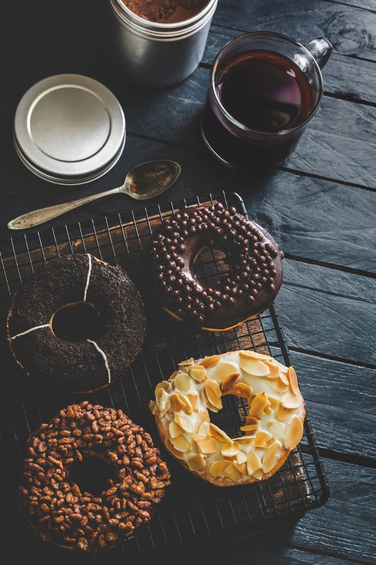 Assorted donuts and coffee on a dark table.