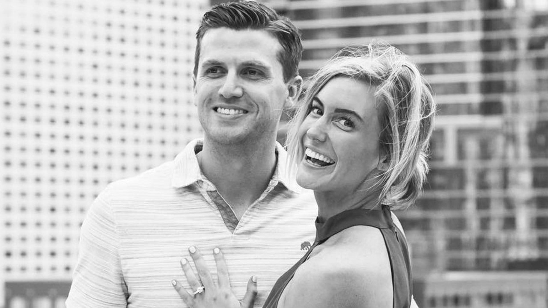 Smiling couple posing in urban setting.