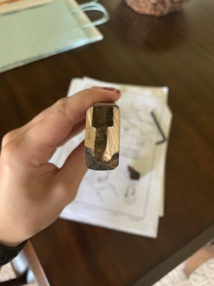 Hand holding a rectangular wooden object.