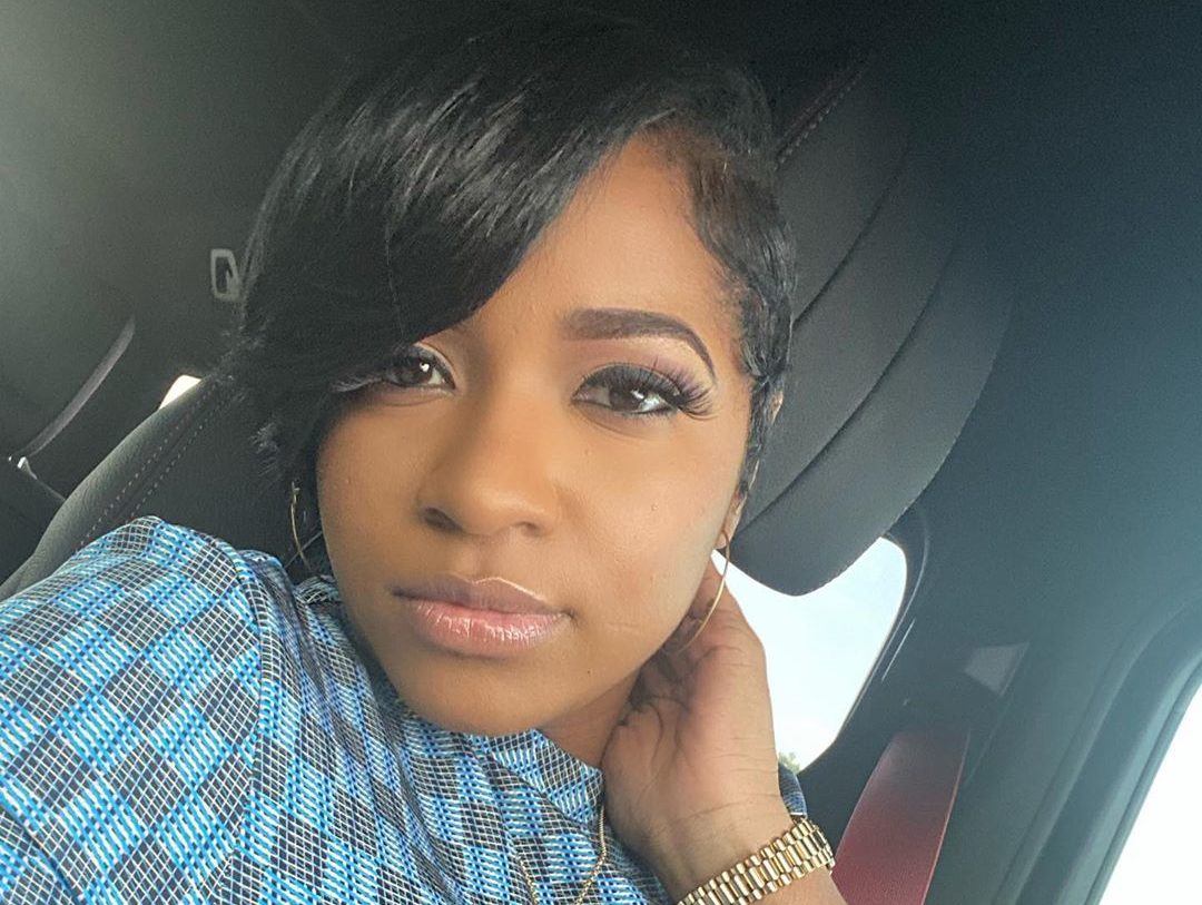 Woman in car with blue patterned top.